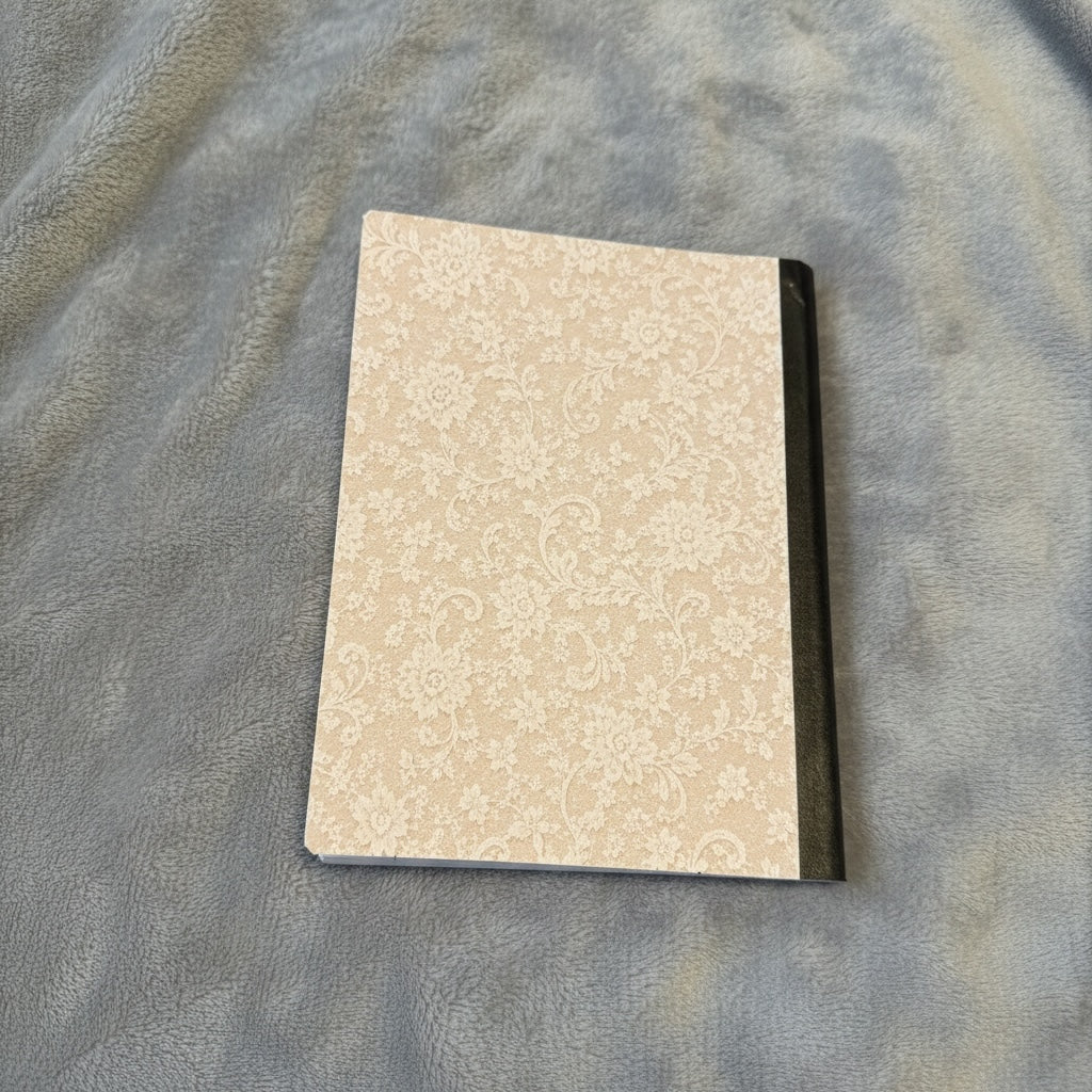 Titch of Everything I Said Yes wedding keepsake journal with a cream lace-patterned cover on a soft grey blanket